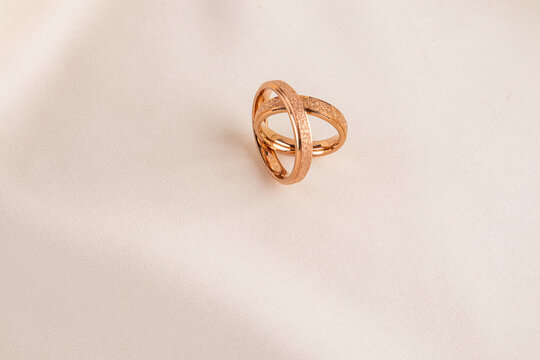 Elegant wedding rings on a soft fabric background