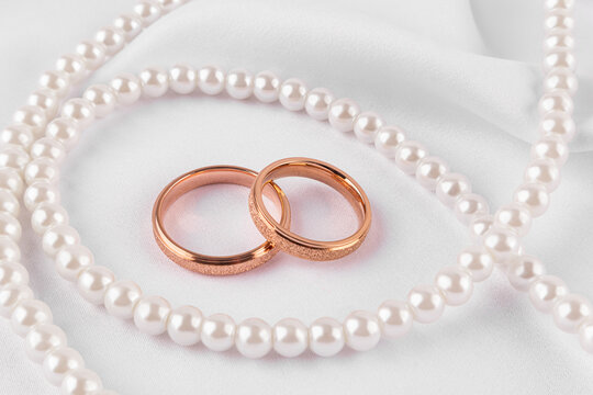 Wedding rings with pearls on white fabric