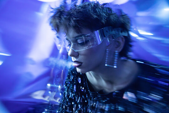 Cyberpunk young woman wearing futuristic virtual reality visor