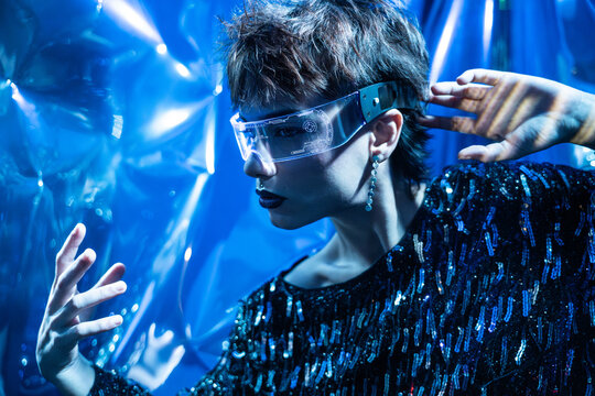 Cyberpunk young woman using vr visor in neon blue light