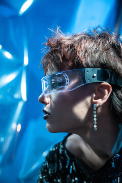 Cyberpunk young woman in vr visor with neon blue light