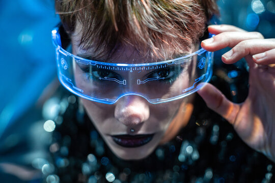 Young woman wearing futuristic virtual reality visor in neon