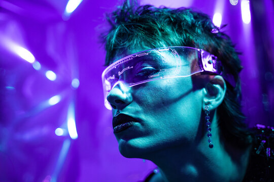 Futuristic cyberpunk young woman wearing virtual reality visor