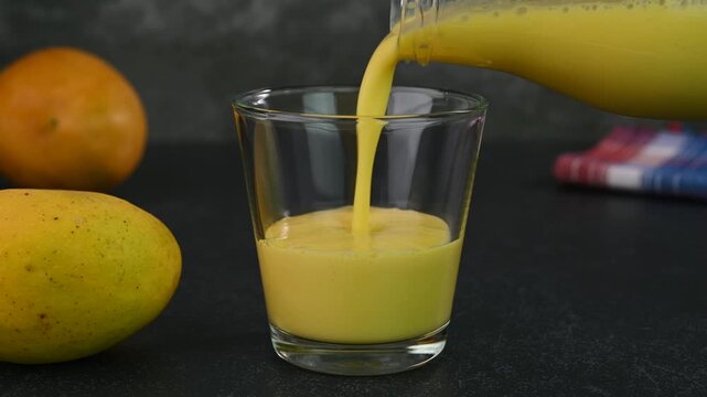 Serving mango lassi in a glass cup.