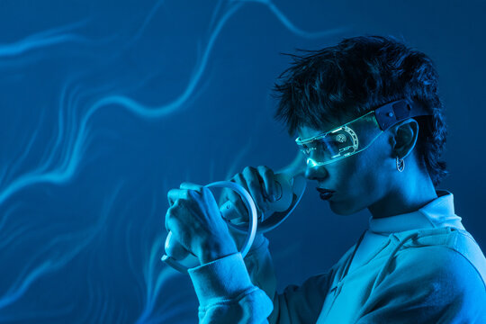 Futuristic young woman using virtual reality in neon blue