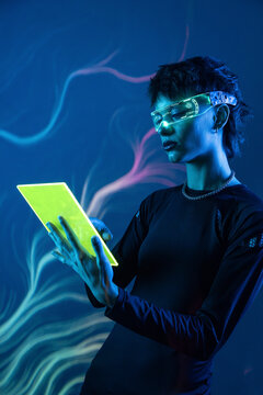 Futuristic cyberpunk woman using VR visor and tablet