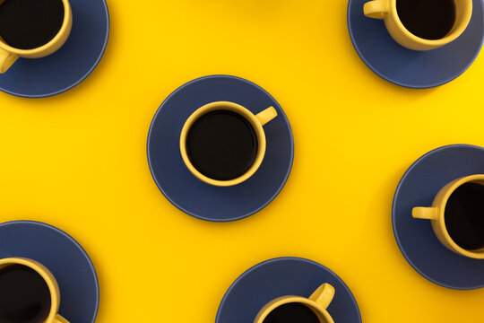 Top view of black coffee cups on bright yellow background