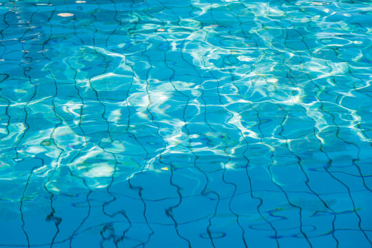 Clear swimming pool water with sunlight reflections