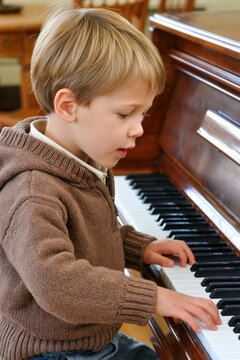 A young boy plays the piano.