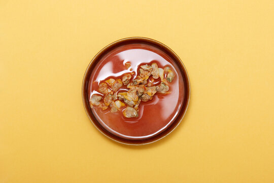 Spanish tapas plate with marinated cockles on yellow