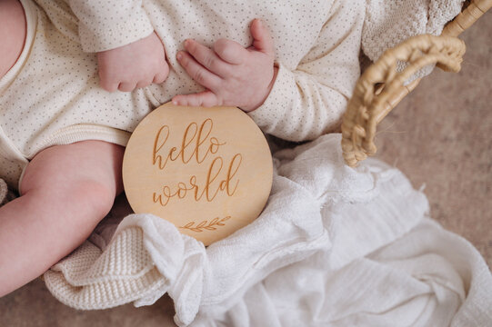 One month baby boy with hello world sign and blanket