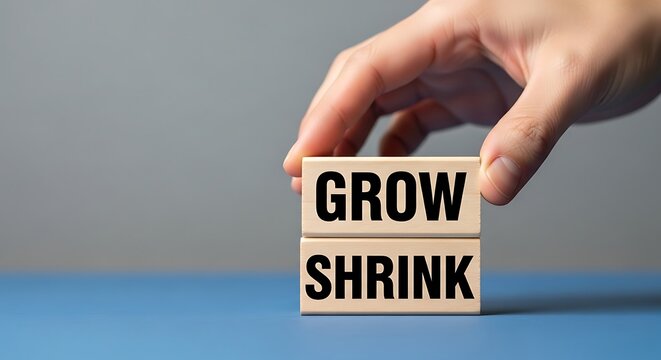 Business growth and shrink concept with wooden blocks, hand stacking grow and shrink text cubes, financial expansion and contraction metaphor