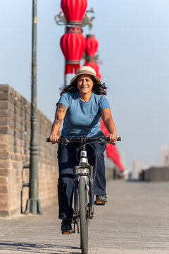 Woman biking on Xi'an ancient city wall with red lanterns