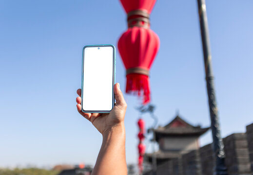 Tourist holding smartphone with blank screen in Xian street