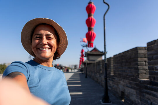 Smiling woman tourist taking selfie on Xi'an ancient wall