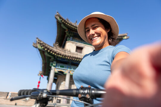 Smiling woman biking on Xi'an ancient city wall tower