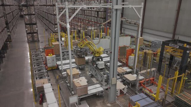 M&aacute;quina industrial automatizada moviendo cajas en f&aacute;brica, sistema de transporte y manipulaci&oacute;n de materiales en planta de producci&oacute;n