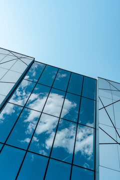 Modern glass building reflecting a blue sky