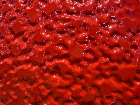 Abstract red metallic texture background with glossy highlights