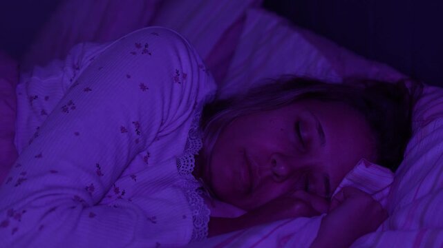 Young woman sleeps in bed at night and suddenly twitches from hypnagogic jerks. Sleep disturbance, involuntary movement and nervous system concept