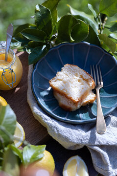 Sweet lemon curd with cake slice on rustic table