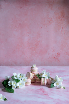 Pink macarons with pistachio cream and white flowers