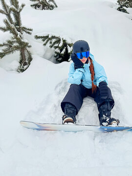 Snowboarder resting in deep snow during winter adventure