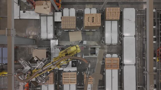 M&aacute;quina industrial automatizada moviendo cajas en f&aacute;brica, sistema de transporte y manipulaci&oacute;n de materiales en planta de producci&oacute;n