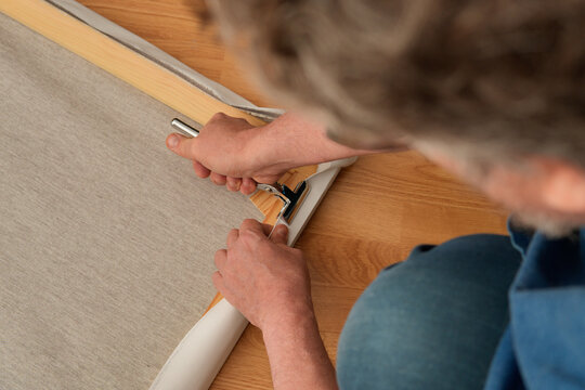 Stretching canvas on wooden stretcher with tension clamp