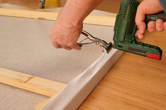Stretching canvas on wooden frame with staple and clamp
