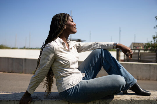 Serene woman with braids enjoying outdoor lifestyle