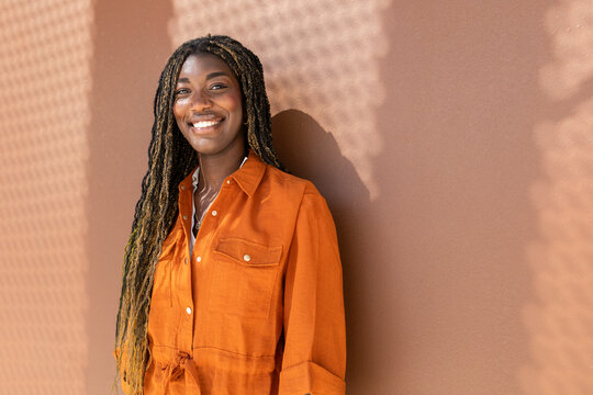 Woman with braids smiling in outdoor setting
