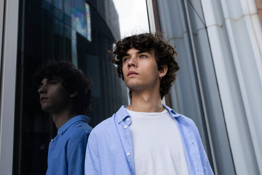 Curly-haired man in city street lifestyle portrait