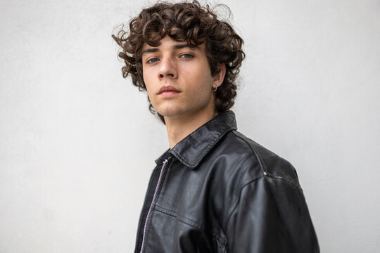 Curly haired man in leather jacket lifestyle portrait