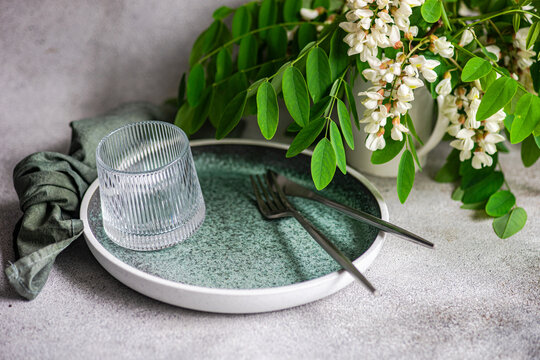 Minimal table setting with acacia flower and glassware