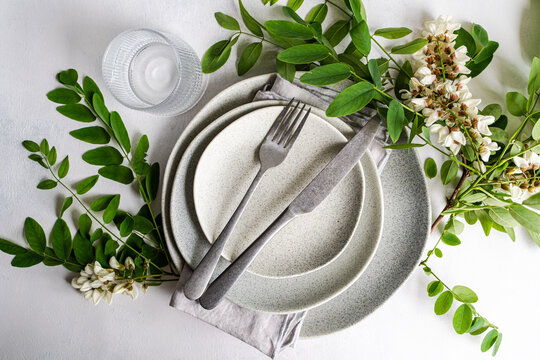 Minimal table setting with acacia flower greenery flat lay