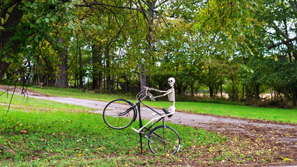 Fototapeta premium Decorative Skeleton On Old Bicycle Displayed Outdoors For Halloween Celebration