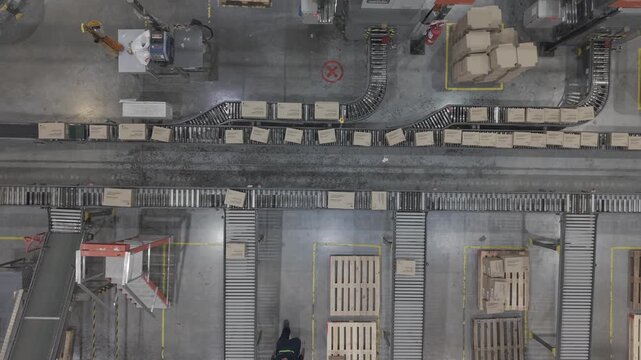 F&aacute;brica en funcionamiento con cinta transportadora y cajas en proceso, obreros trabajando en producci&oacute;n industrial vista cenital, footage industria, trabajo, industrializaci&oacute;n, desarrollo