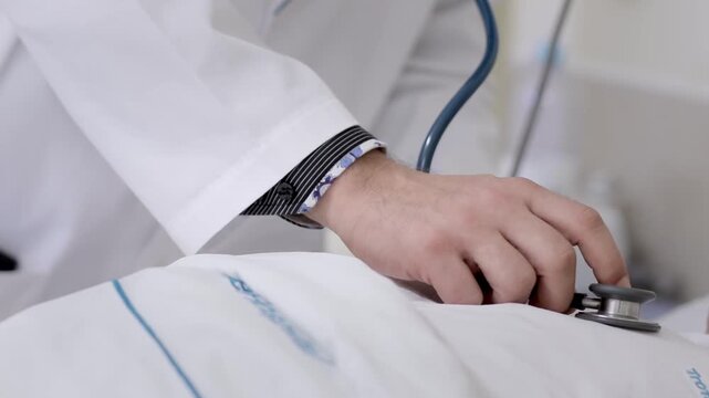 M&eacute;dico a auscultar paciente deitado na cama de hospital