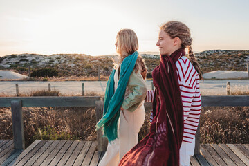 Fototapeta premium Girls walking on path near the beach with relaxed fashion accessories and natural styling
