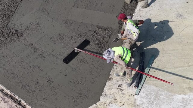 Obreros pavimentando una calle, construcci&oacute;n de asfalto y trabajo urbano de infraestructura