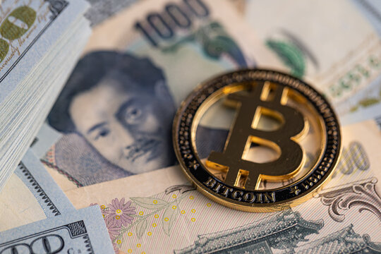 Gold Bitcoin coin on US dollar and Japanese yen banknotes