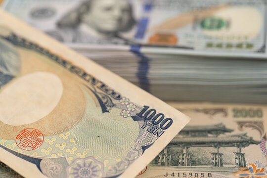 US hundred dollar bills and Japanese yen banknotes background