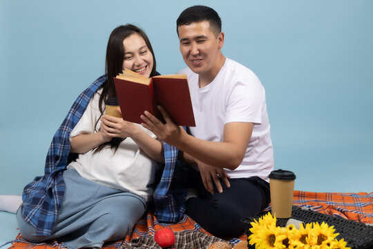 Couple reading a book together at a picnic