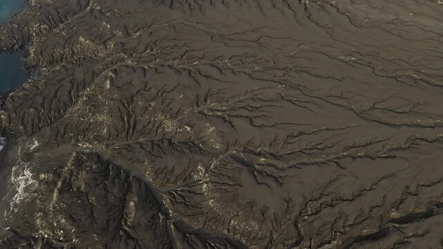Aerial Over Vast Volcanic Ash Plain With Erosion Patterns