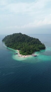 Aerial Of Small Tropical Jungle Island With Beach And Boats