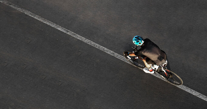 Aerial top drone high view of sporty male Cyclist with helmet shorts riding cross bicycle isolated on asphalt road background  showing man on racing bicycle riding Motion tour de france Active wear