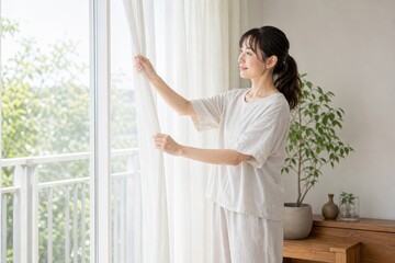 Fototapeta premium ベランダ窓を開ける女性の朝の換気