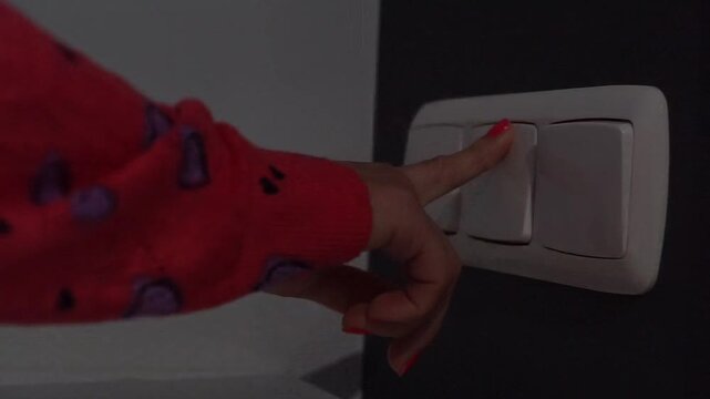 Child Turning Off Wall Light Switch In Dark Room