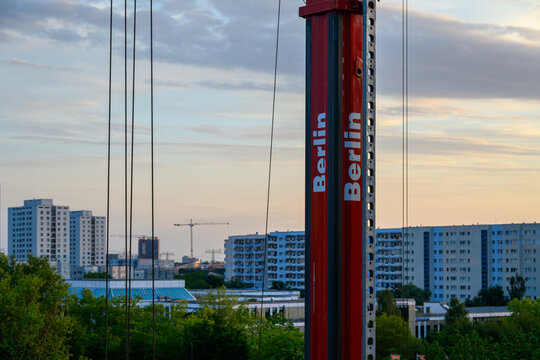 Berlin Skyline with Red shown clearly in the frame in an outdoor setting, with urban surroundings, under golden-hour light, with a natural mood, suitable for marketing, editorial.